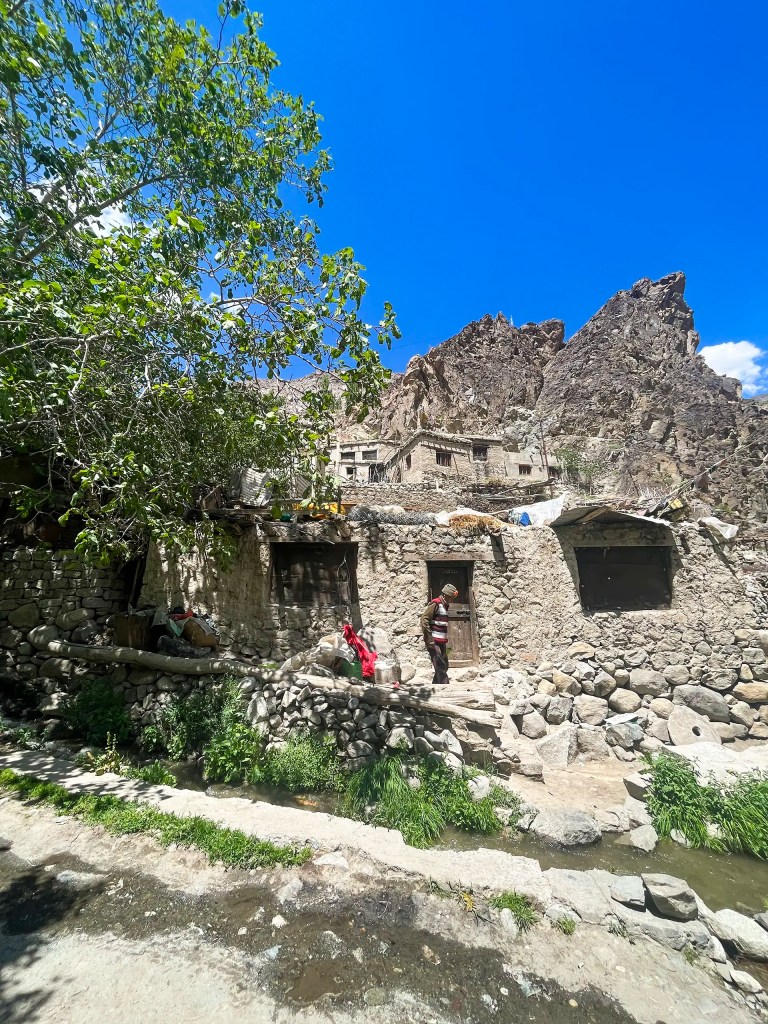 Stone houses and local resident in Dah village Aryan Valley Ladakh with mountains in background